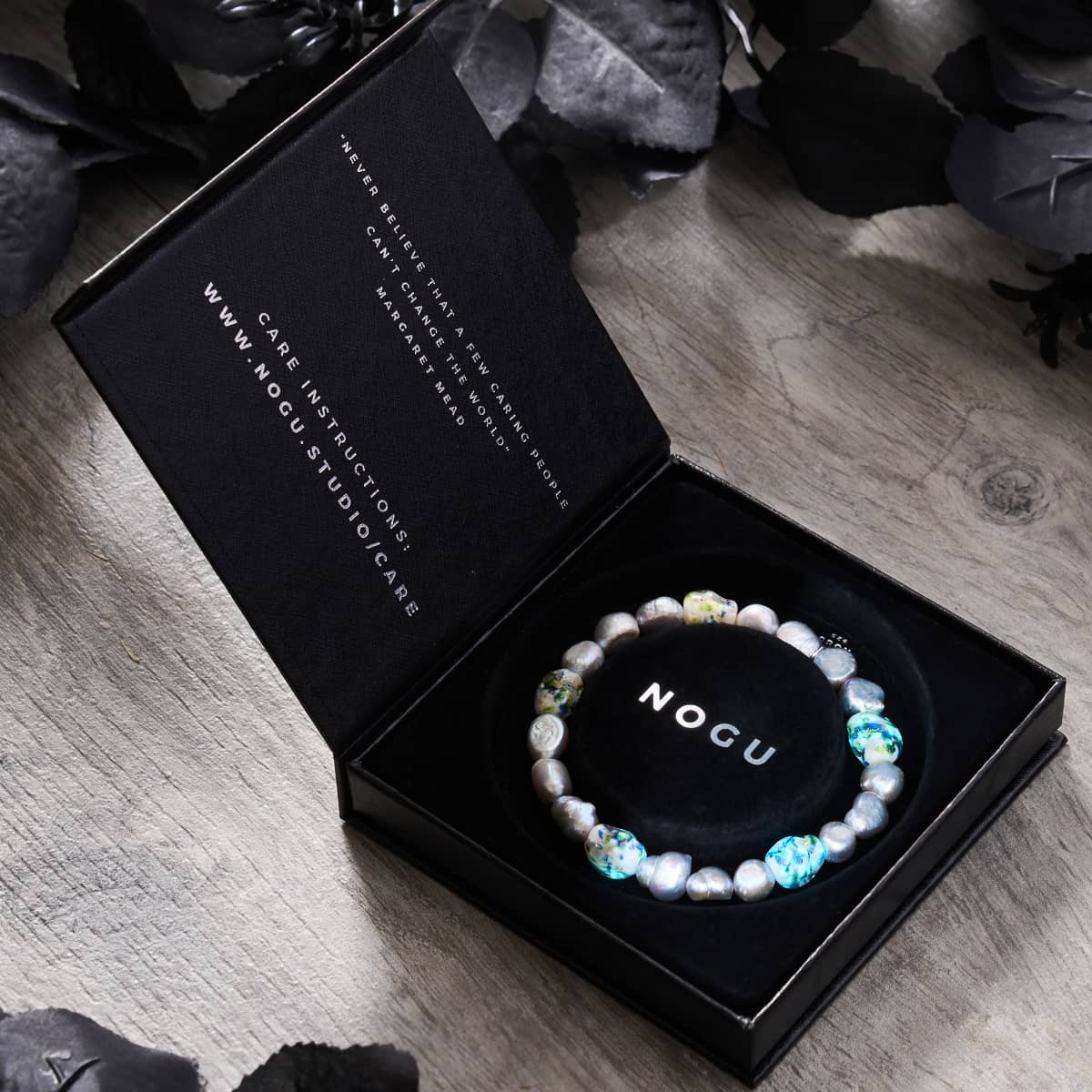 Ethereal Gloom bracelet with opal silver freshwater pearls and glow-in-the-dark Firefly Glass skulls in black gift box by NOGU